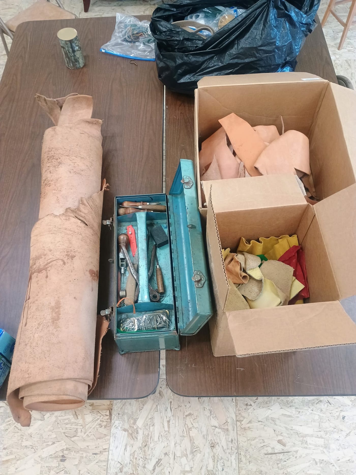 A box of leather tools and a roll of leather