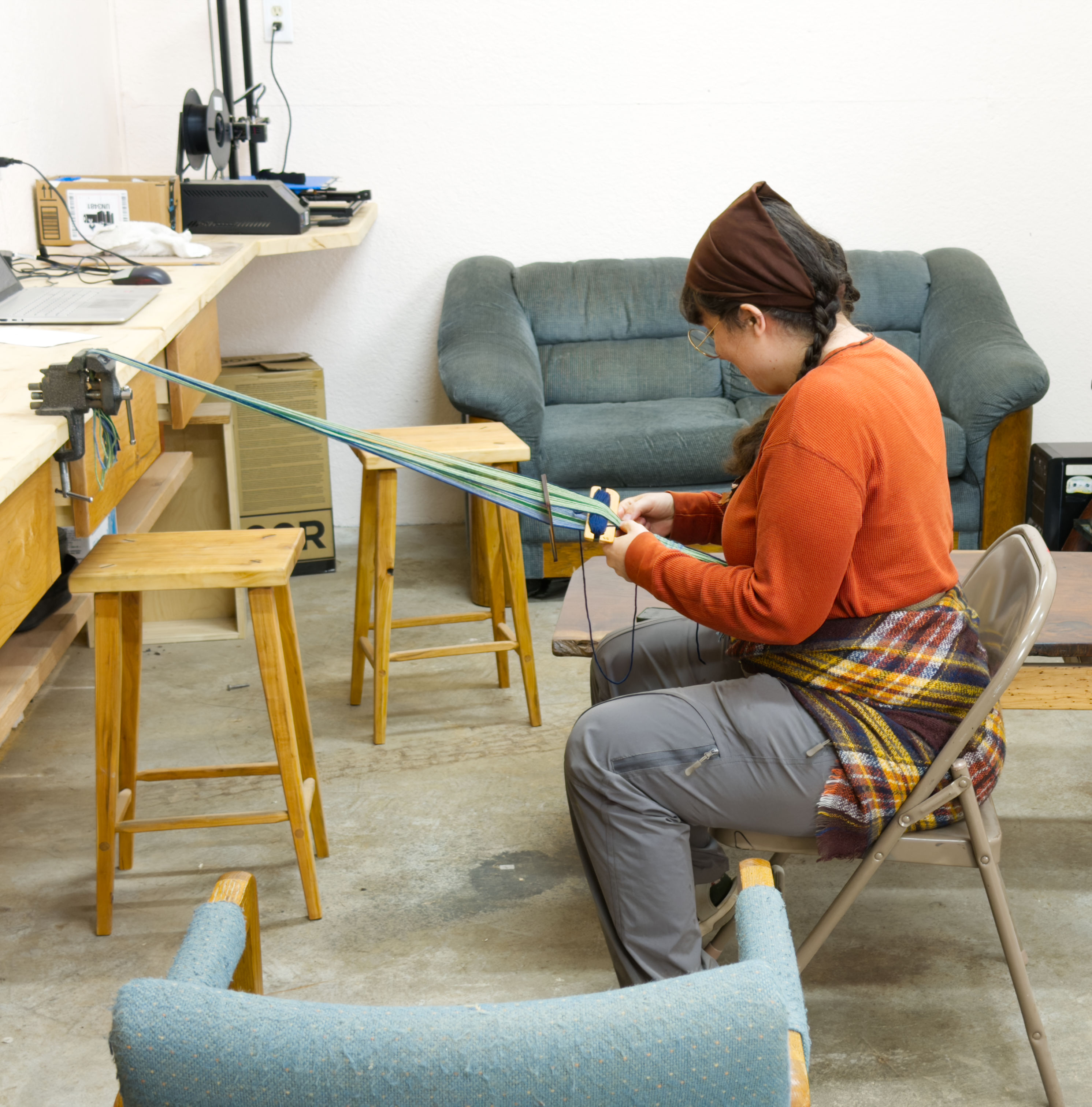 A woman weaving on a small loom