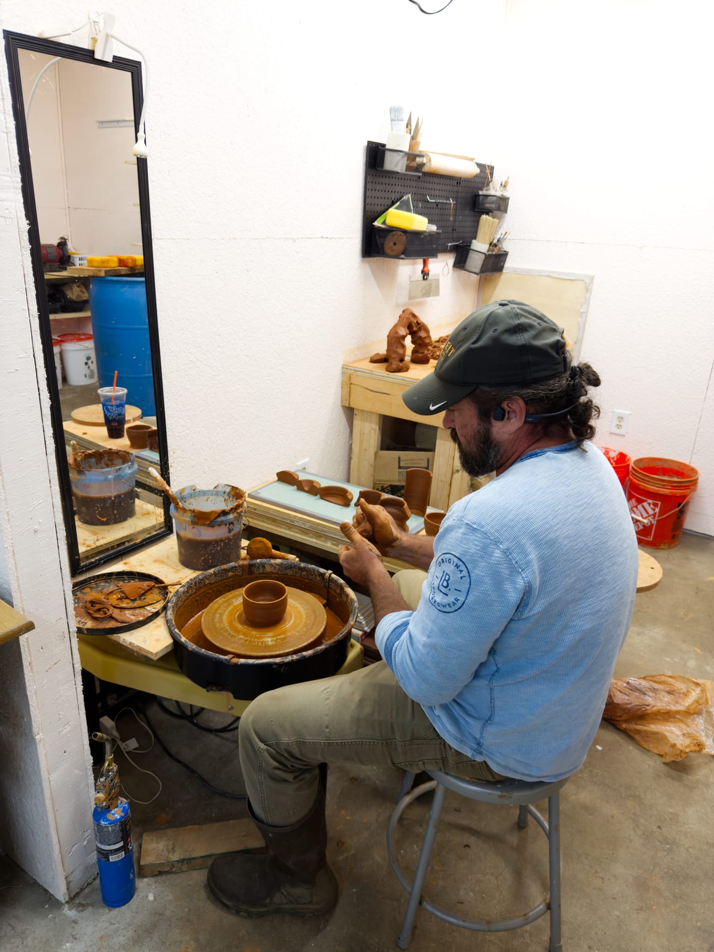 A man throwing a small bowl on a pottery wheel